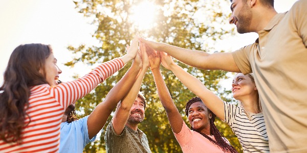 Gruppe junger Leute beim High Five geben in der Natur